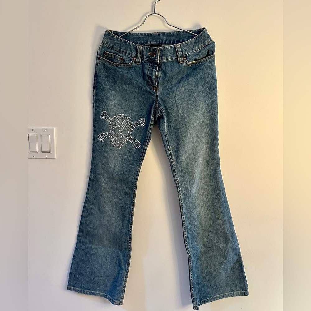 Denim jeans with rhinestone skull on thigh